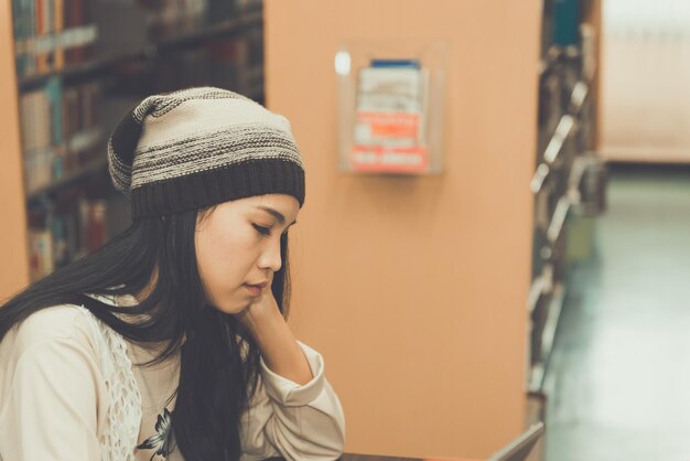 Asian sad girl in the library vintage stylethai woman stress from loveheartbreak conceptdark tone