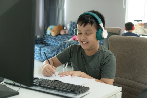 asian school boy showing the enjoyment during online learning course during school at home