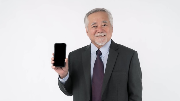 Asian senior businessman old man with suit feel happy good health showing smart phone with blank screen black screen isolated on white background Mock Up Image