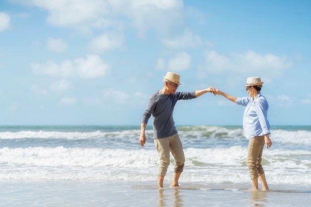 Asian senior couple dancing on the beach.elderly honeymoon together very happiness after retirement.plan life insurance.Activity after retirement on summertime