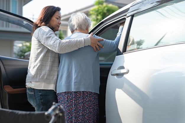 Asian senior or elderly old lady woman patient sitting on wheelchair prepare get to her car healthy strong medical concept