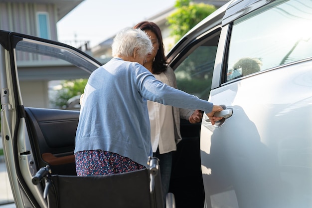 Asian senior or elderly old lady woman patient sitting on wheelchair prepare get to her car healthy strong medical concept