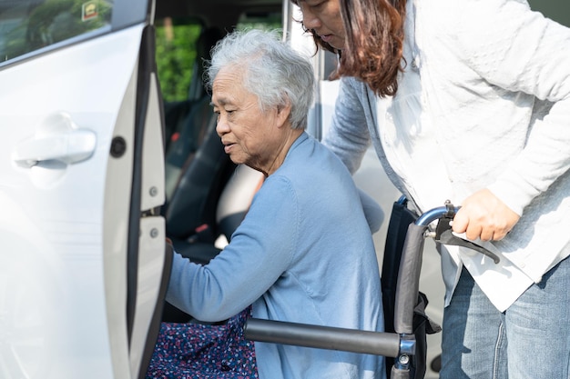 Asian senior or elderly old lady woman patient sitting on wheelchair prepare get to her car healthy strong medical concept