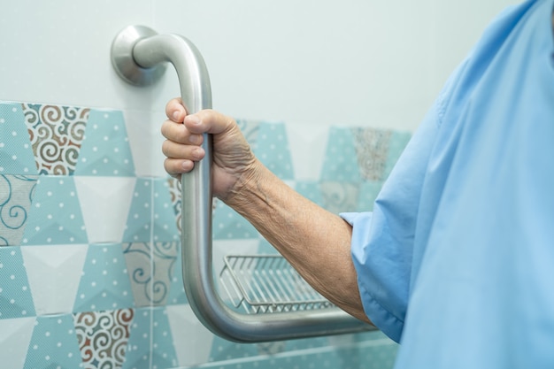 Asian senior or elderly old lady woman patient use slope walkway handle security with help support assistant in nursing hospital ward; healthy strong medical concept.