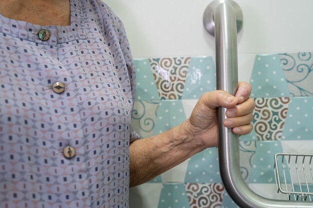 Asian senior or elderly old lady woman patient use toilet bathroom handle security in nursing hospital ward, healthy strong medical concept.