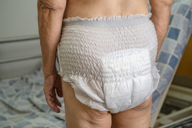 Asian senior or elderly old lady woman patient wearing incontinence diaper in nursing hospital ward healthy strong medical concept