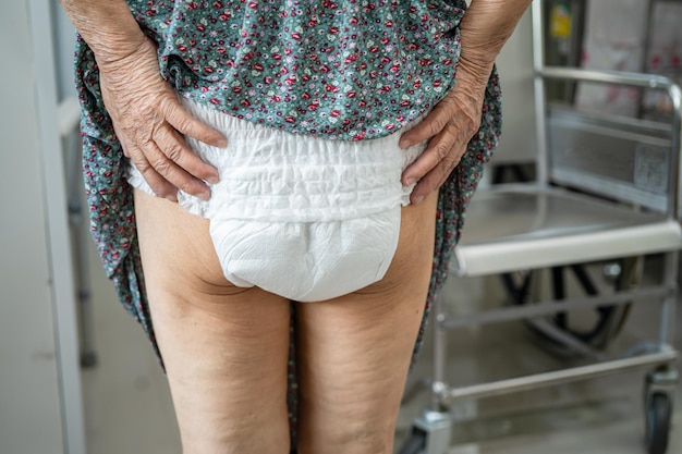 Asian senior or elderly old lady woman patient wearing incontinence diaper in nursing hospital ward healthy strong medical concept