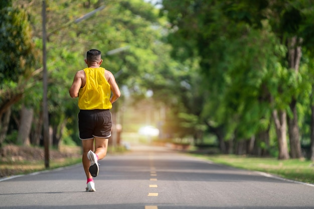 Asian senior man in fitness wear running in a park Healthy lifestyle concept