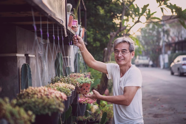 Asian senior man smiling with happiness face standing at home garden