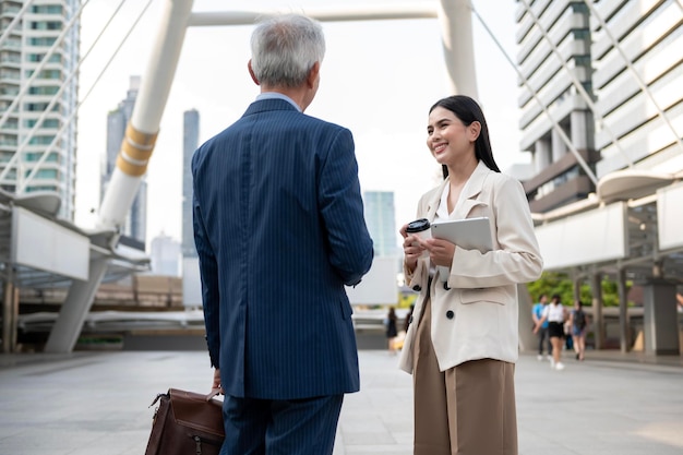 Asian senior mature middle aged businessman and young businesswoman having a discussion