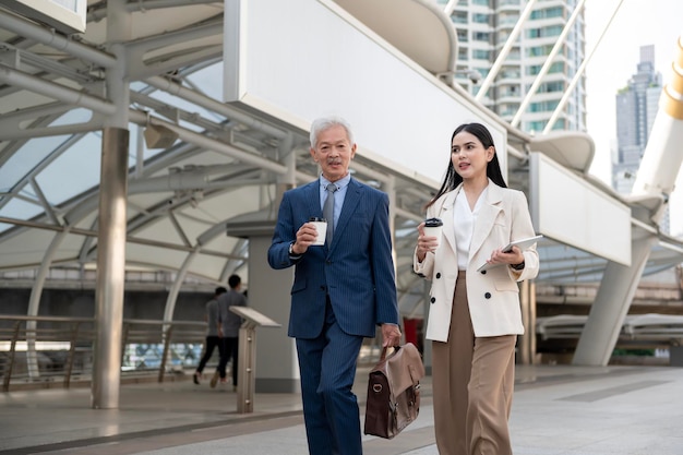 Asian senior mature middle aged businessman and young businesswoman having a discussion