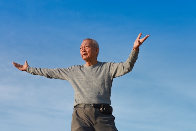 Asian Senior old man practice Taichi Chinese Kungfu on the beach