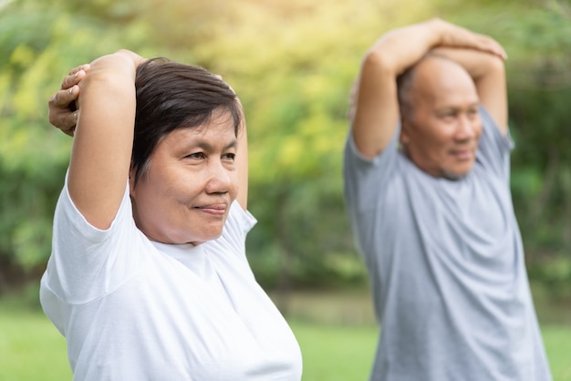 Asian senior people stretching their arms before exercising.