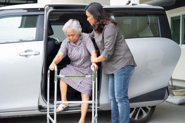 Asian senior woman patient sitting on walker prepare get to her car healthy strong medical concept