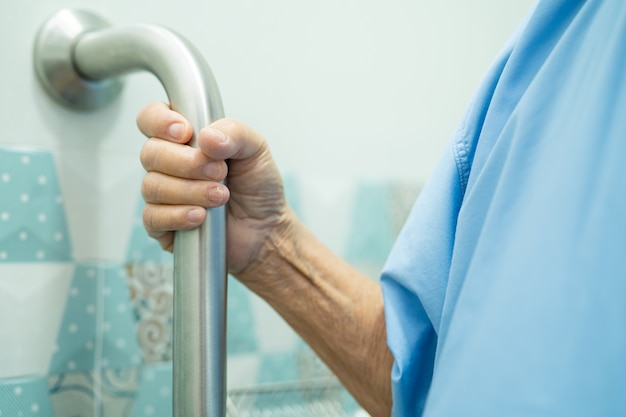 Asian senior woman patient use slope walkway handle security in toilet