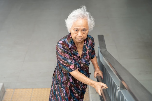 Asian senior woman patient use slope walkway handle security with help support assistant healthy strong medical concept