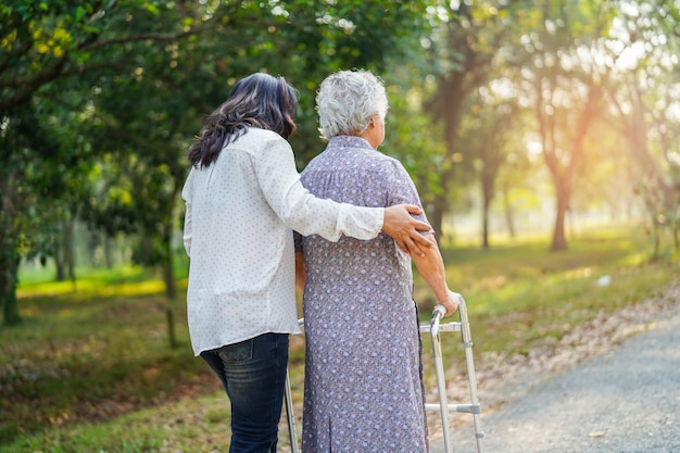 Asian senior woman use walker in park.