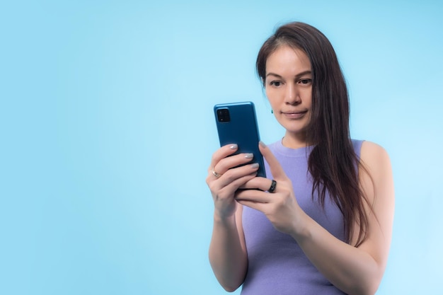 Asian senior woman using smart phone with blue background