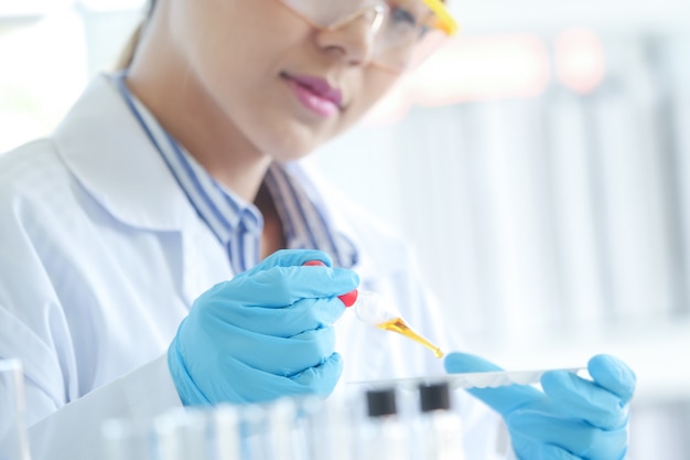 Asian Serious female chemist working in laboratory