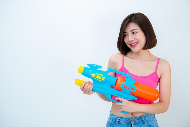 Asian sexy woman with gun water in hand on white backgroundFestival songkran day at thailandThe best of festival of thaiLand of smile