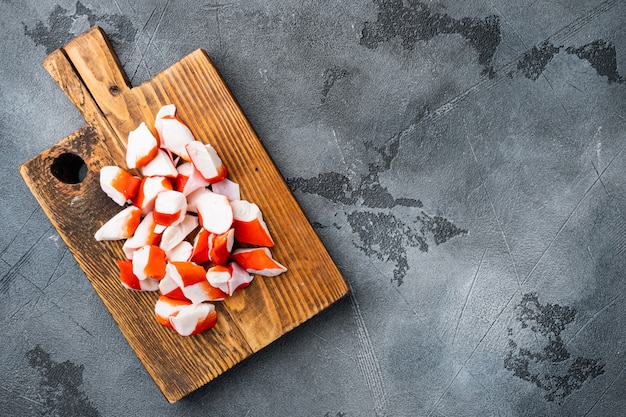 Asian snack surimi set, on wooden cutting board, on gray background, top view flat lay , with copyspace  and space for text