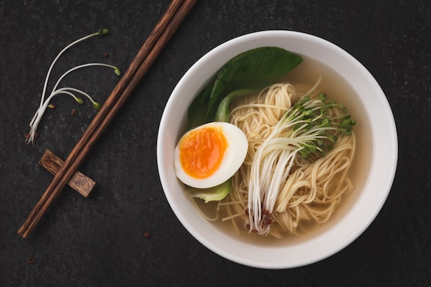 Photo asian soup noodles (ramen) with egg on dark background