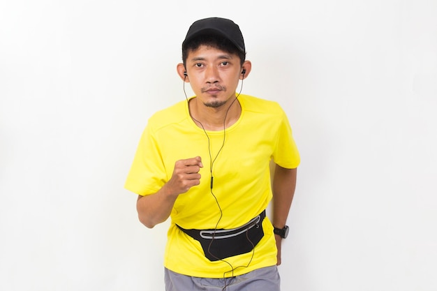 asian sporty man dressed in yellow tshirt running isolated on white background