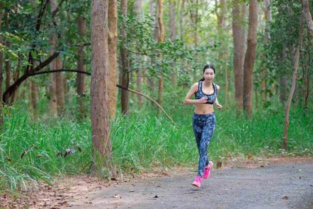 Asian sporty woman Jogginh in the parkThailand peopleFitness and exercise conceptWarm up body