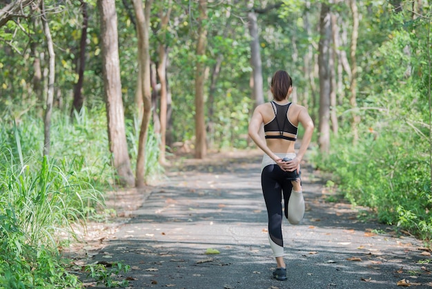 Asian sporty woman stretching body breathing fresh air in the parkThailand peopleFitness and exercise conceptJogging in the park