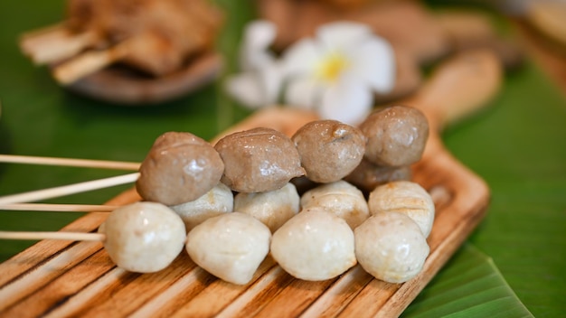 Asian street food concept Grilled meat balls and grilled pork balls on a wooden plate closeup