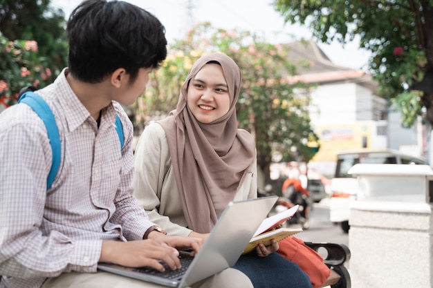 Asian student colleagues working on a laptop