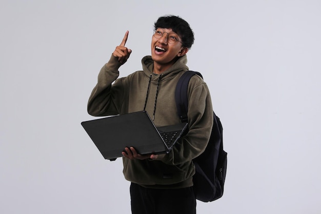 Asian student guy using laptop and pointing his finger up to express his idea