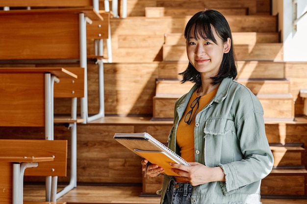 Asian student standing at auditorium of university