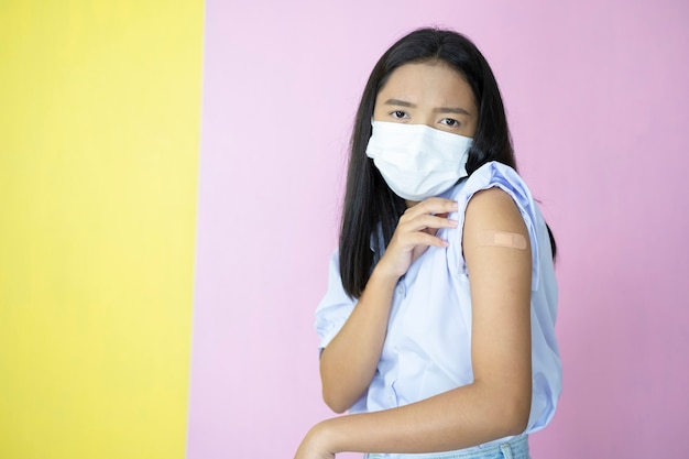 Asian student vaccination on pink background.