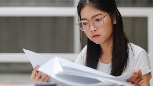 Asian student woman reading books in library at university