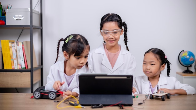 Asian students learn at home by coding robot cars and electronic board cables in STEM STEAM mathematics engineering science technology computer code in robotics for kids' concepts