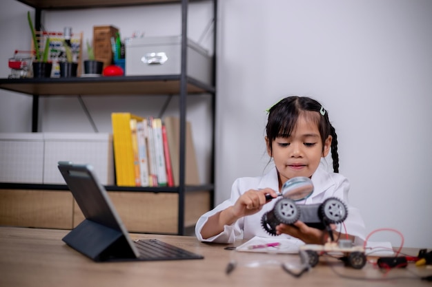 Asian students learn at home by coding robot cars and electronic board cables in STEM STEAM mathematics engineering science technology computer code in robotics for kids' concepts