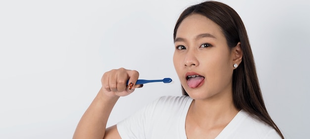 Asian teen facial with braces and toothbrush smiling to camera to show dental orthodonic teeth which include professional metal wire material from orthodontist