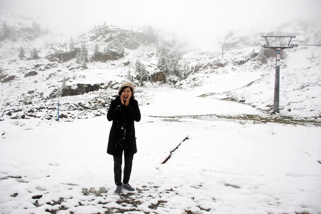 Asian thai women playing and posing for take photo with snow at top of mountain in Kaunergrat nature park while snowing in Tyrol Austria