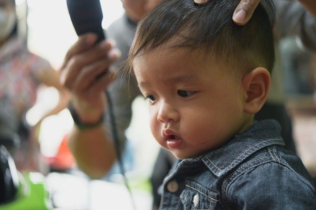 Asian Toddler child getting his first haircut.