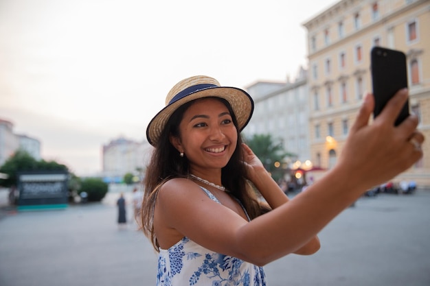 An asian tourist takes a selfie with her smartphone while on vacation in italy