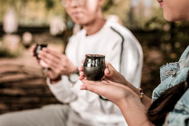 Asian tradition. Relaxed young people enjoying their free time while drinking tasty tea