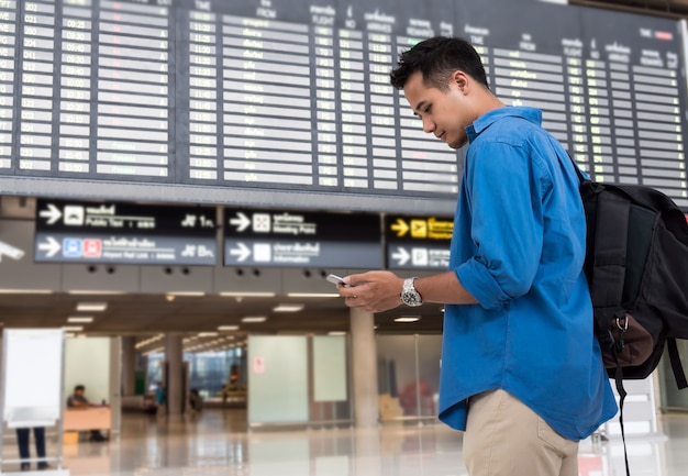 Asian traveler using the smart mobile phone for check-in