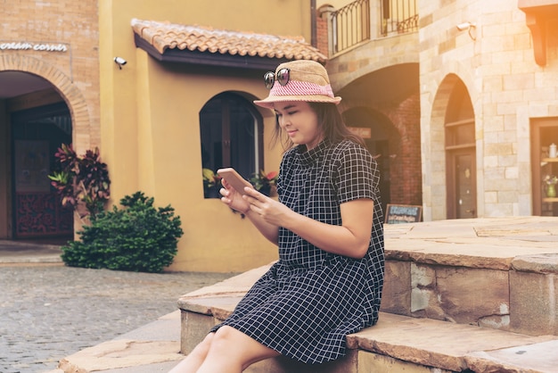 Asian traveler using smartphone while traveling in Europe.