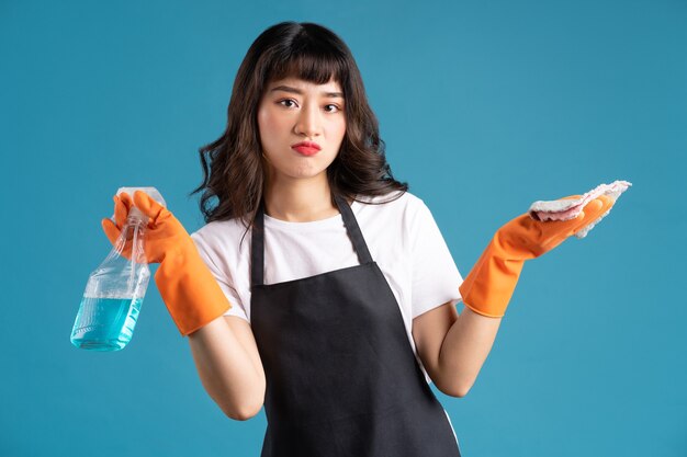 Asian woman in an apron and gloves preparing for the cleaning job