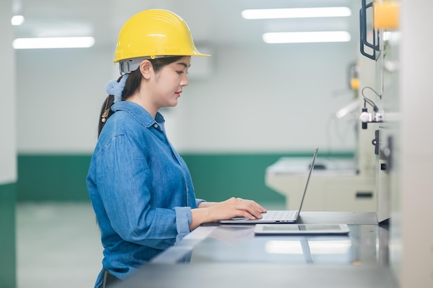 Asian woman are engineer factory inspecting machine in factory with computer Asian woman engineer working in factory concept