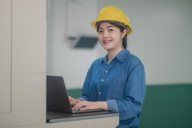 Asian woman are engineer factory inspecting machine in factory with computer Asian woman engineer working in factory concept