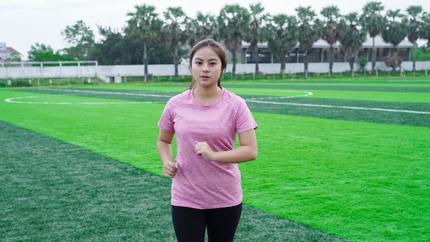 Asian woman athlete running on track