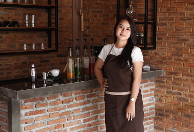 Asian woman barista smilling look camera at cafe