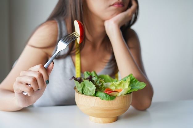 Asian woman boring to eat salad or diet food. Diet concept